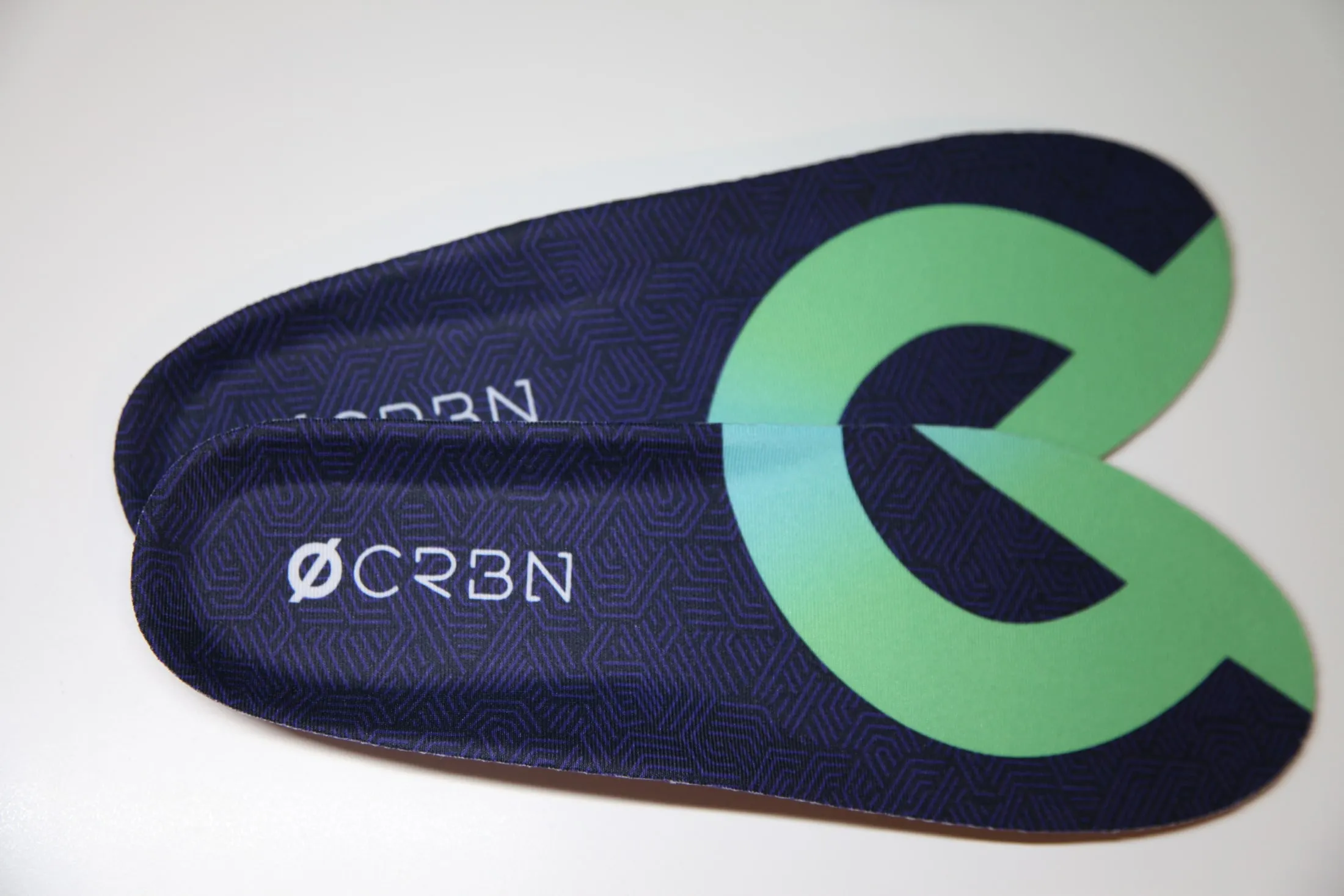 A pair of CRBN V2 insoles showing the printed top sheets